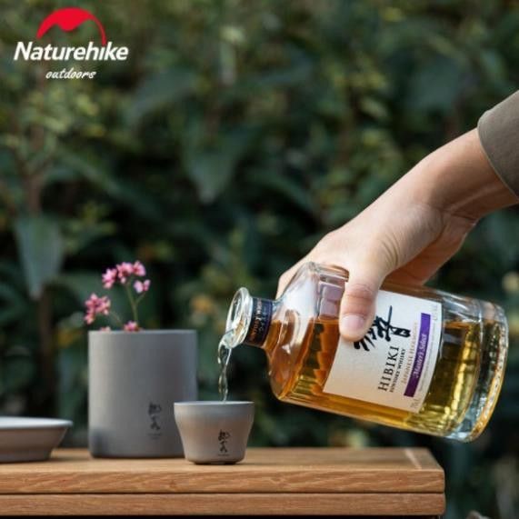 Ly rượu Titanium 2 lớp Glamping NatureHike NH20CJ020 đặt cạnh bàn cắm trại