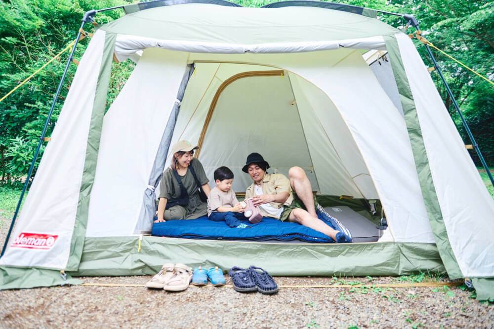 Một gia đình thư giãn trong căn lều bên trong lều bên xe hơi của Coleman